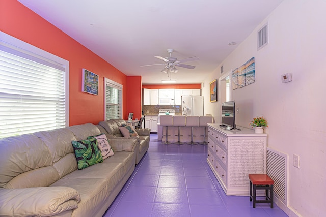 living area with visible vents and a ceiling fan