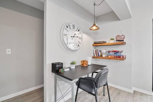 dining space featuring light wood finished floors and baseboards