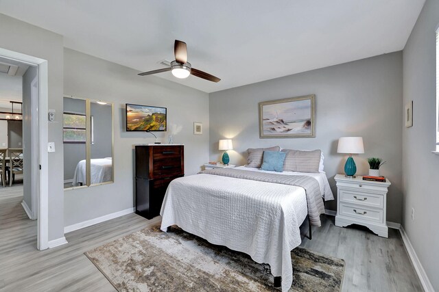 bedroom with baseboards, light wood finished floors, and ceiling fan