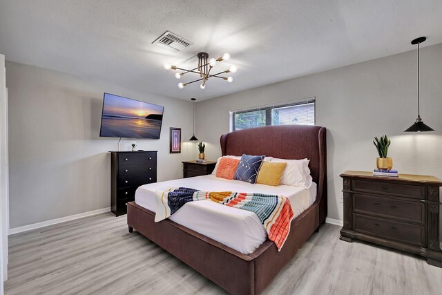 bedroom featuring baseboards, light wood-style floors, attic access, and a ceiling fan