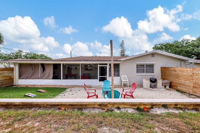 rear view of property with a patio area, a lawn, fence, and a sunroom