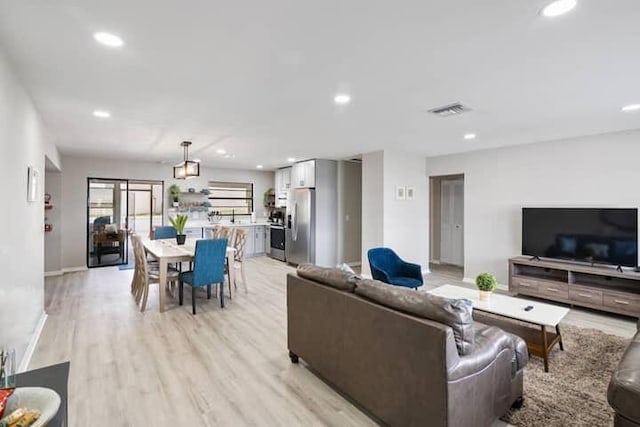 living room with visible vents, recessed lighting, baseboards, and light wood-style floors