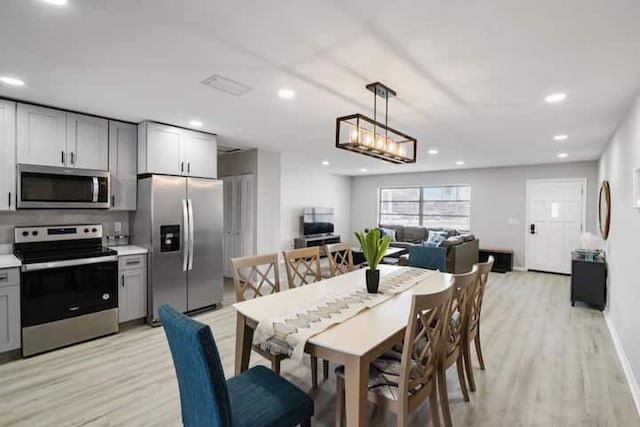 dining room with recessed lighting, baseboards, and light wood finished floors