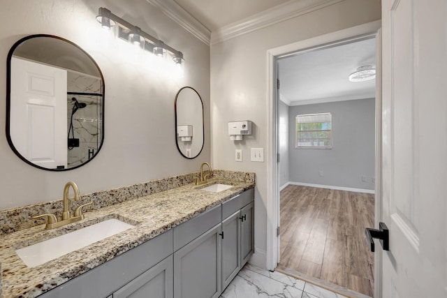 bathroom featuring crown molding, double vanity, and a sink