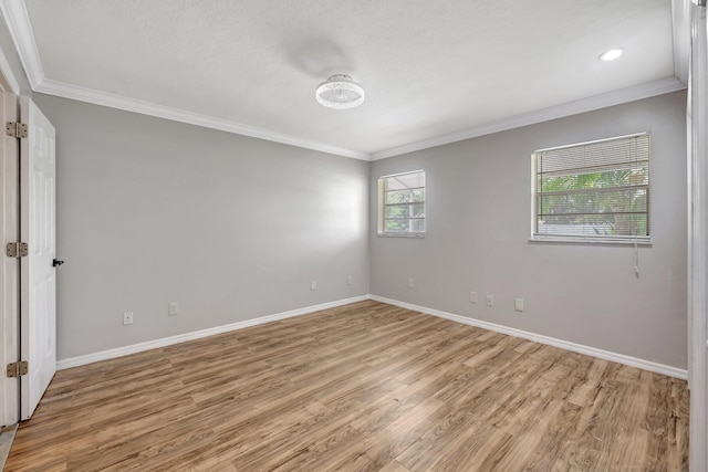 empty room with baseboards, light wood-style floors, and ornamental molding