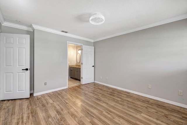 unfurnished bedroom with baseboards, visible vents, light wood finished floors, ensuite bathroom, and crown molding