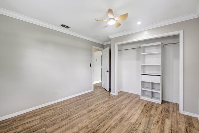 unfurnished bedroom featuring crown molding, wood finished floors, visible vents, and baseboards