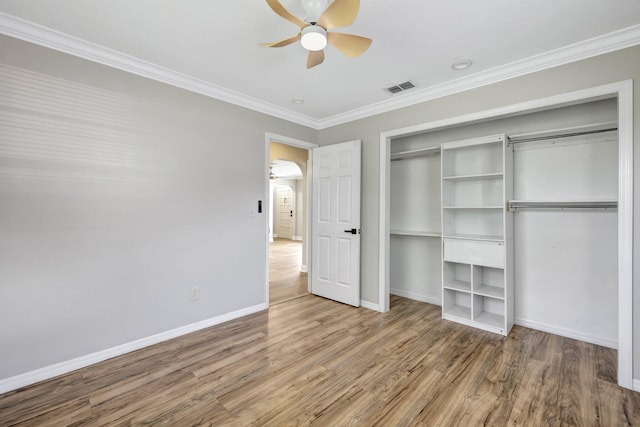 unfurnished bedroom with visible vents, baseboards, wood finished floors, and ornamental molding