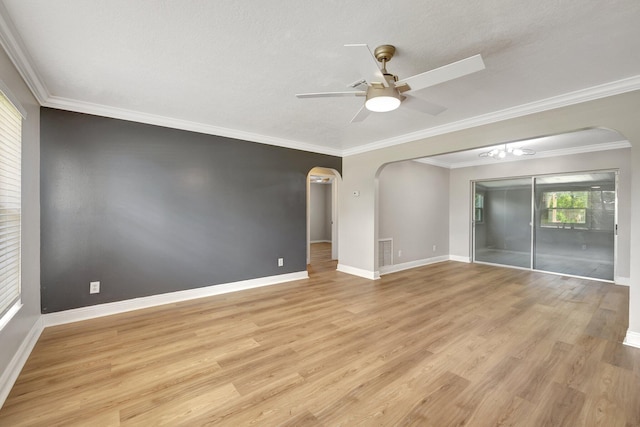 unfurnished room featuring light wood-style flooring, arched walkways, and ceiling fan