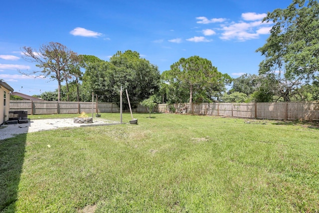 view of yard featuring a patio area, a fenced backyard, and an outdoor fire pit