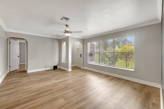 unfurnished living room with visible vents, arched walkways, ceiling fan, light wood-style floors, and crown molding