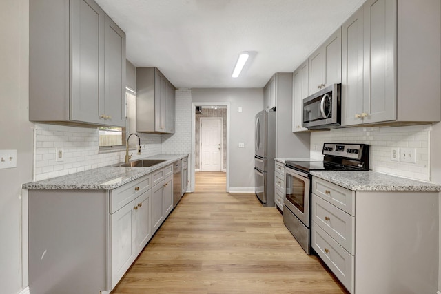 kitchen featuring light wood-style flooring, appliances with stainless steel finishes, and gray cabinetry