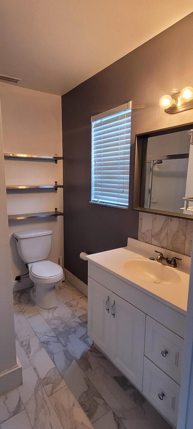 full bathroom with marble finish floor, a shower, vanity, and toilet