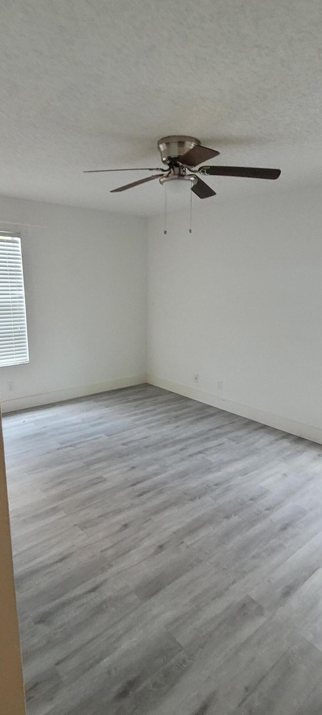 unfurnished room with a textured ceiling and wood finished floors