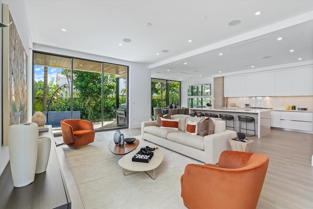 living area featuring light wood-style flooring, expansive windows, and recessed lighting