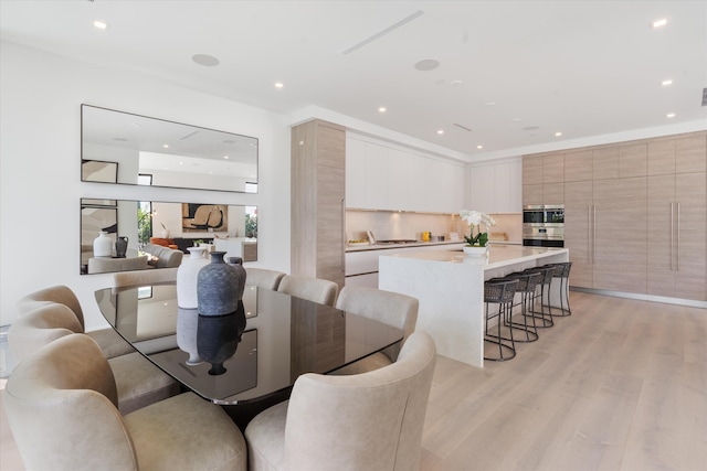 dining space with recessed lighting and light wood-style floors