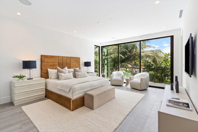 bedroom with access to exterior, recessed lighting, floor to ceiling windows, and light wood-style flooring