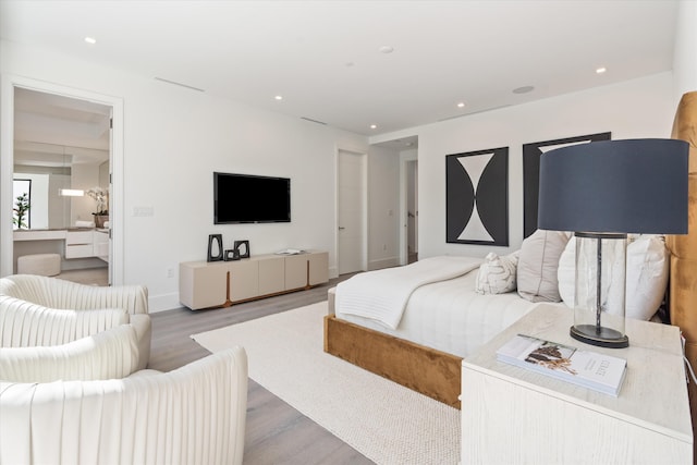 bedroom with baseboards, wood finished floors, and recessed lighting