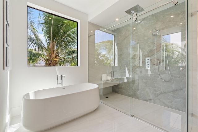 bathroom featuring a marble finish shower and a freestanding bath