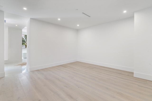 empty room with baseboards, visible vents, light wood-style flooring, and recessed lighting