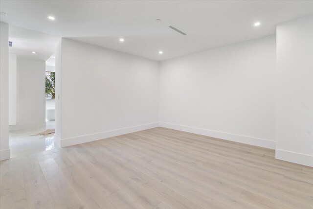 spare room featuring recessed lighting, light wood-style flooring, and baseboards