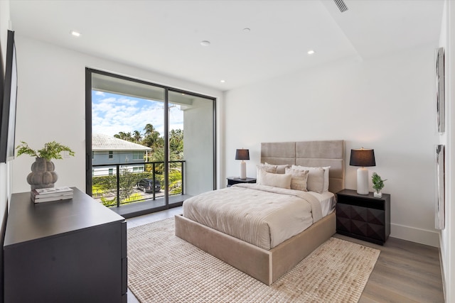 bedroom with access to exterior, baseboards, wood finished floors, and recessed lighting