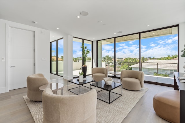 living area featuring light wood-type flooring, expansive windows, and recessed lighting