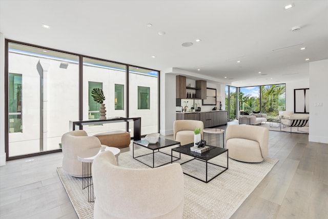 living area featuring expansive windows, recessed lighting, baseboards, and light wood-style floors