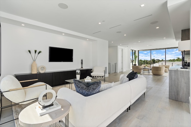 living room featuring light wood finished floors, recessed lighting, and floor to ceiling windows