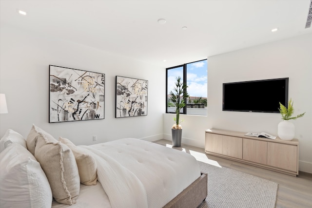 bedroom featuring light wood finished floors, visible vents, baseboards, and recessed lighting