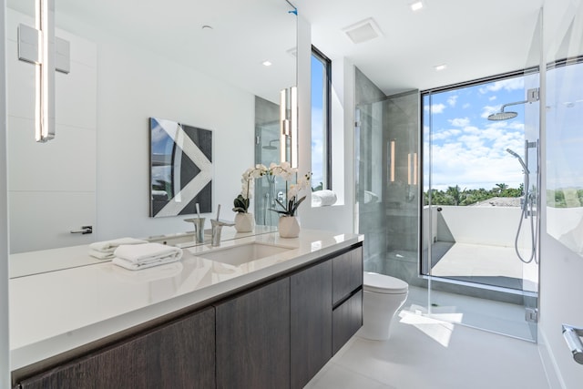 bathroom with expansive windows, toilet, a shower stall, and vanity