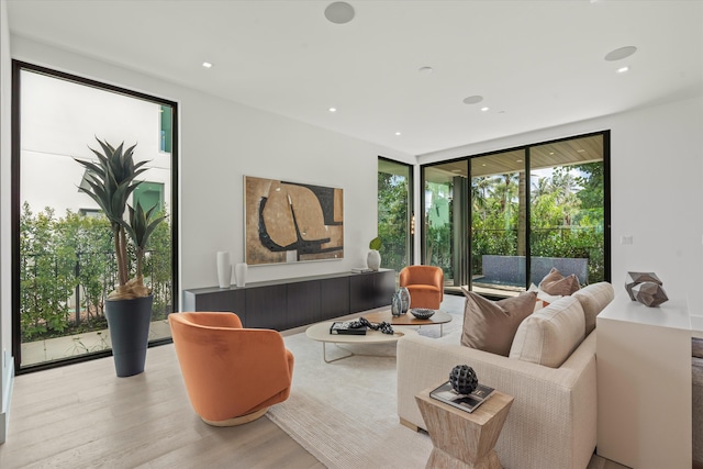 living room with a wall of windows, wood finished floors, and recessed lighting