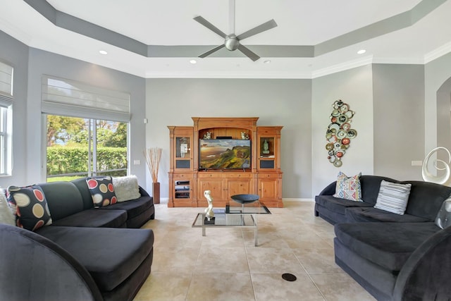 living room featuring a tray ceiling, baseboards, light tile patterned flooring, and a high ceiling