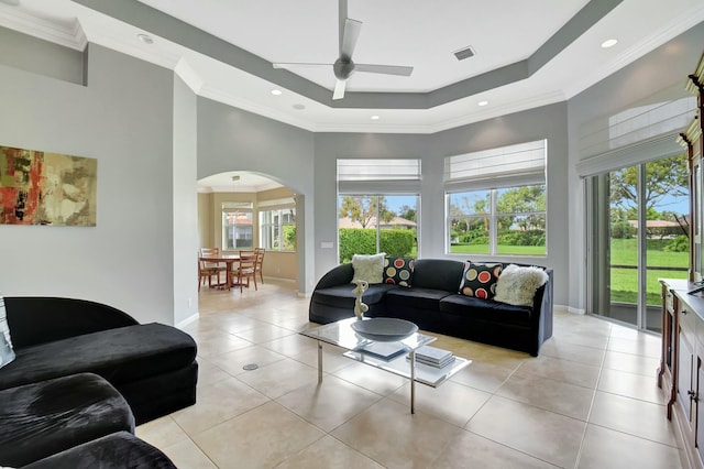 living area featuring a tray ceiling, a wealth of natural light, and light tile patterned flooring