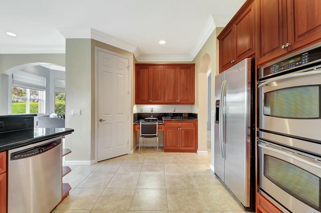 kitchen with stainless steel appliances, dark countertops, backsplash, and light tile patterned floors