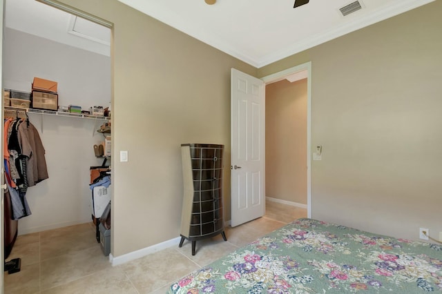 bedroom featuring light tile patterned floors, a closet, visible vents, ornamental molding, and baseboards