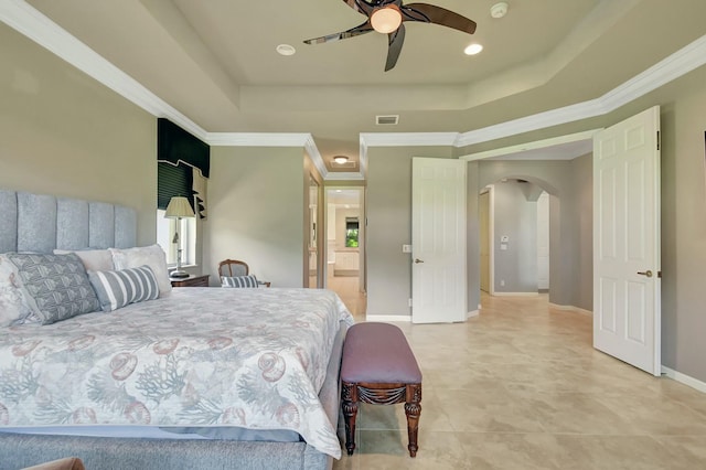 bedroom with arched walkways, a tray ceiling, visible vents, and crown molding