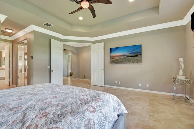 bedroom with baseboards, visible vents, arched walkways, a raised ceiling, and crown molding