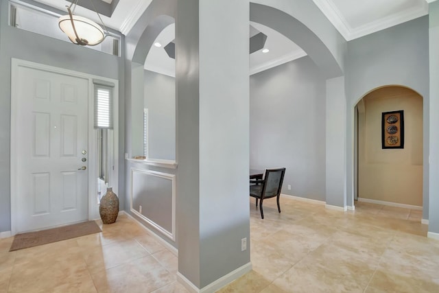 entryway featuring baseboards, light tile patterned floors, arched walkways, and crown molding