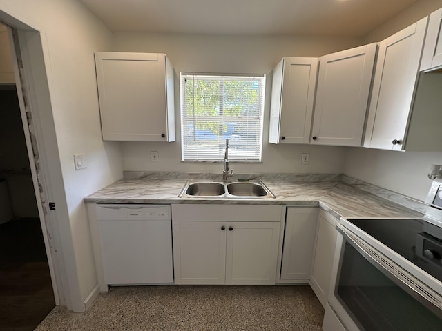 kitchen with white appliances, white cabinetry, light countertops, and a sink