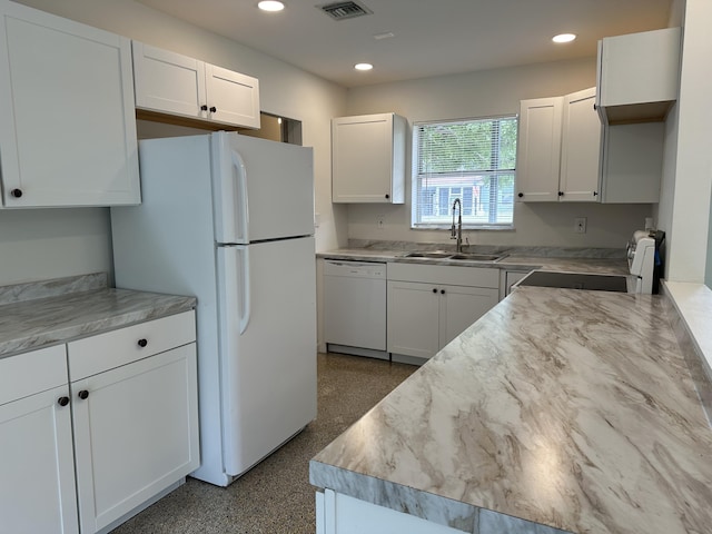 kitchen with white appliances, white cabinetry, light countertops, and a sink