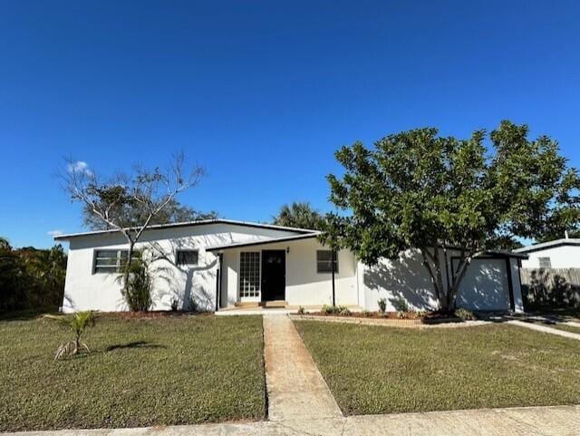 view of front of home with a front lawn and stucco siding