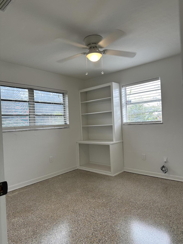 interior space featuring multiple windows, baseboards, and speckled floor