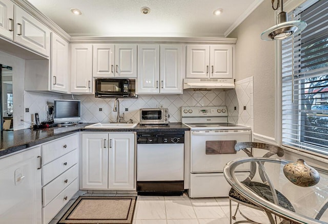 kitchen with white appliances, white cabinets, a sink, and under cabinet range hood