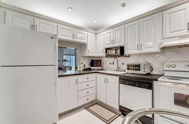 kitchen featuring a toaster, backsplash, a sink, white appliances, and under cabinet range hood