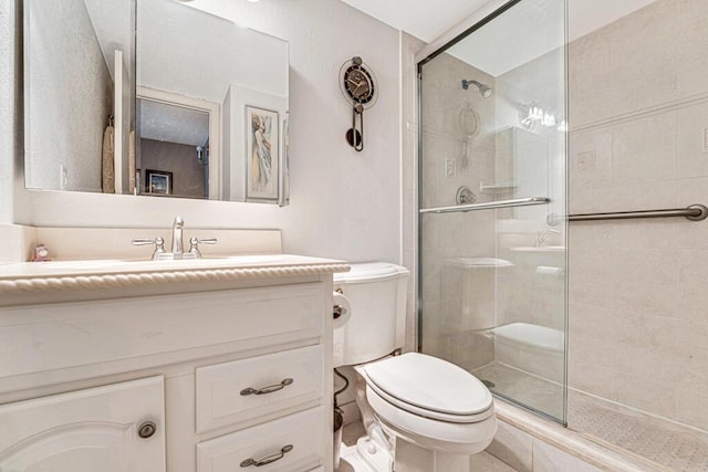 full bathroom featuring toilet, a shower stall, and vanity