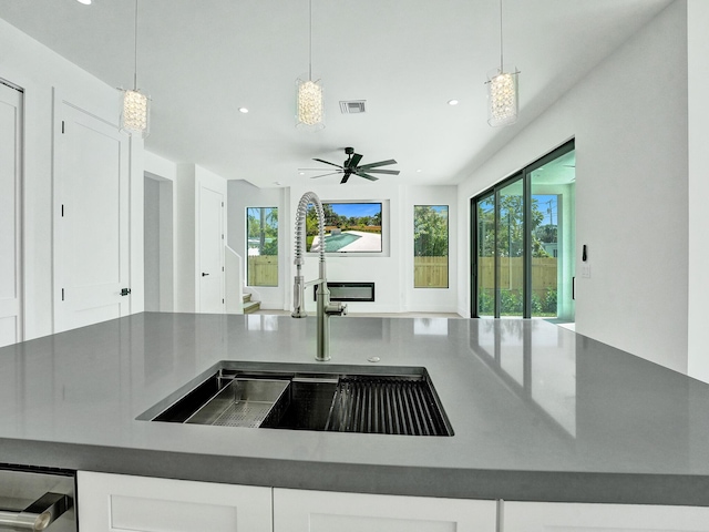 kitchen with plenty of natural light, dark countertops, a sink, and white cabinets