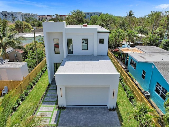 view of front of house with a garage, fence, decorative driveway, and stucco siding