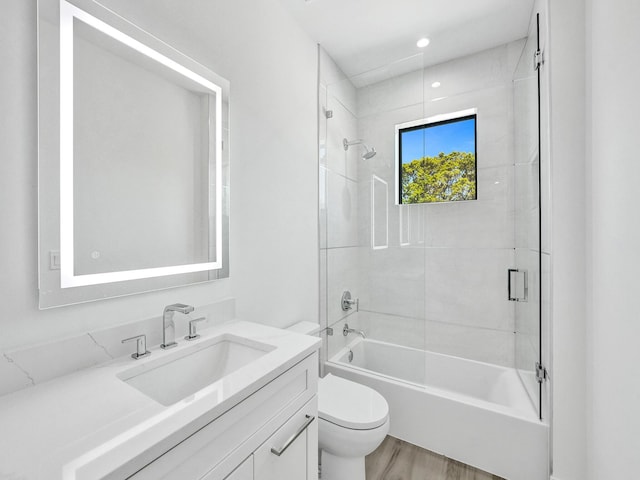 bathroom featuring shower / bathtub combination, toilet, wood finished floors, and vanity