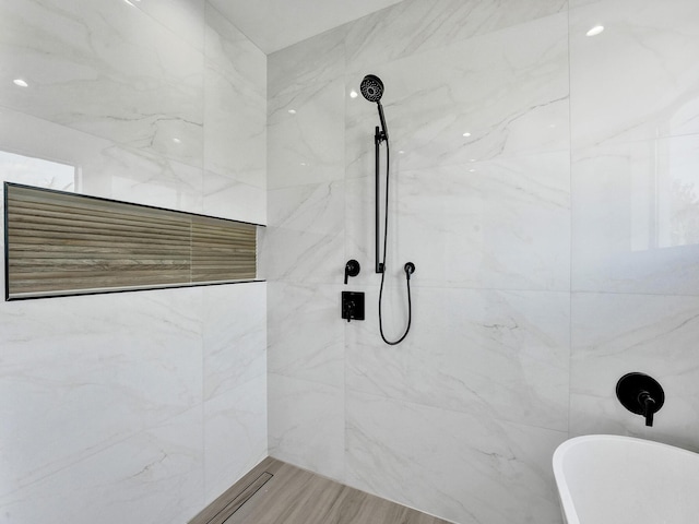 full bathroom with a shower, a freestanding tub, and tile walls